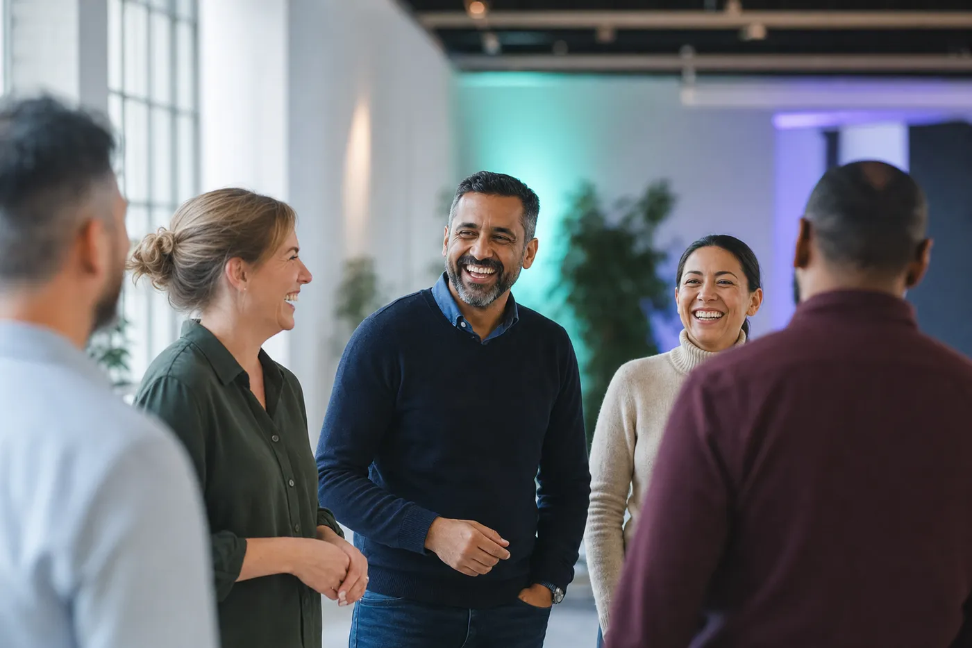 A relaxed team laughing together during a structured team building exercise in a bright workshop space
